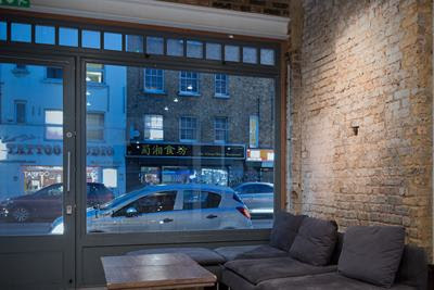 View from the ground floor commercial space out to the Bethnal Green Road shopfront at dusk