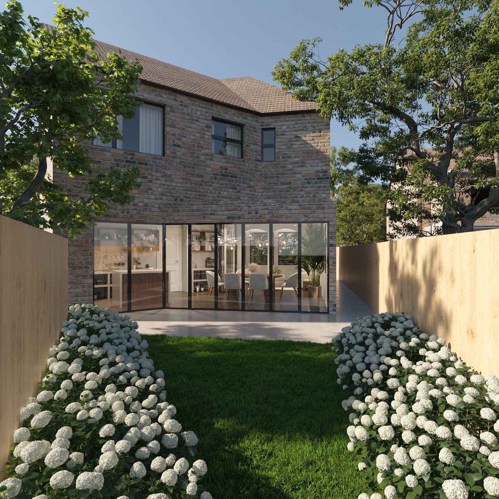 Birch Road — rear elevation from the garden, with full-width steel-framed glazing to the kitchen and dining room and hydrangea borders either side of the lawn
