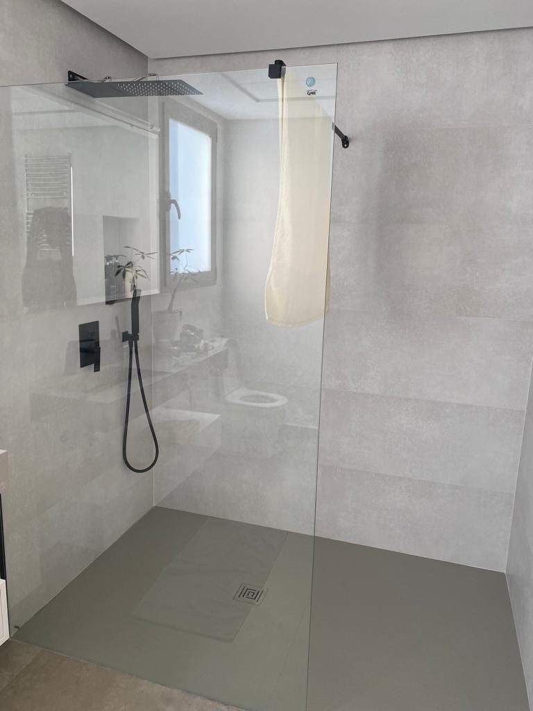 Walk-in shower with frameless glass screen and large-format tiling