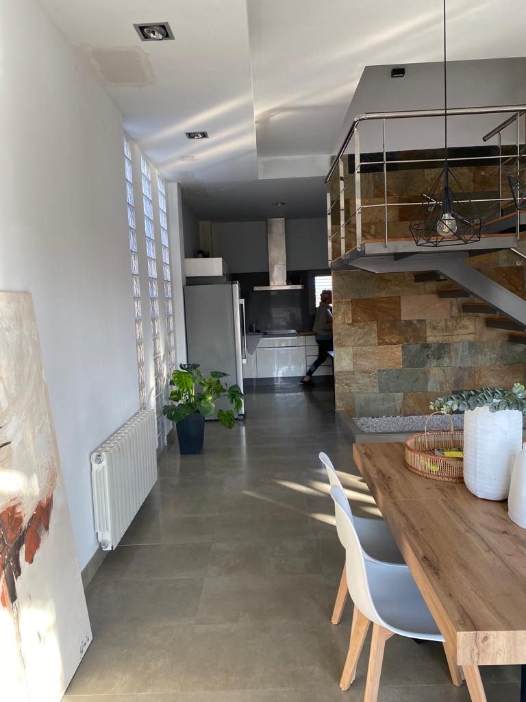 Dining area with the glass-block wall bringing daylight into the stair core, kitchen beyond