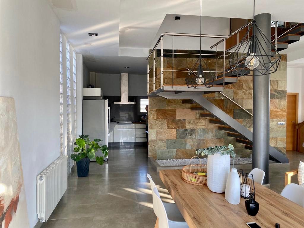 The dining table looking through to the kitchen, with the stone stair wall on the right
