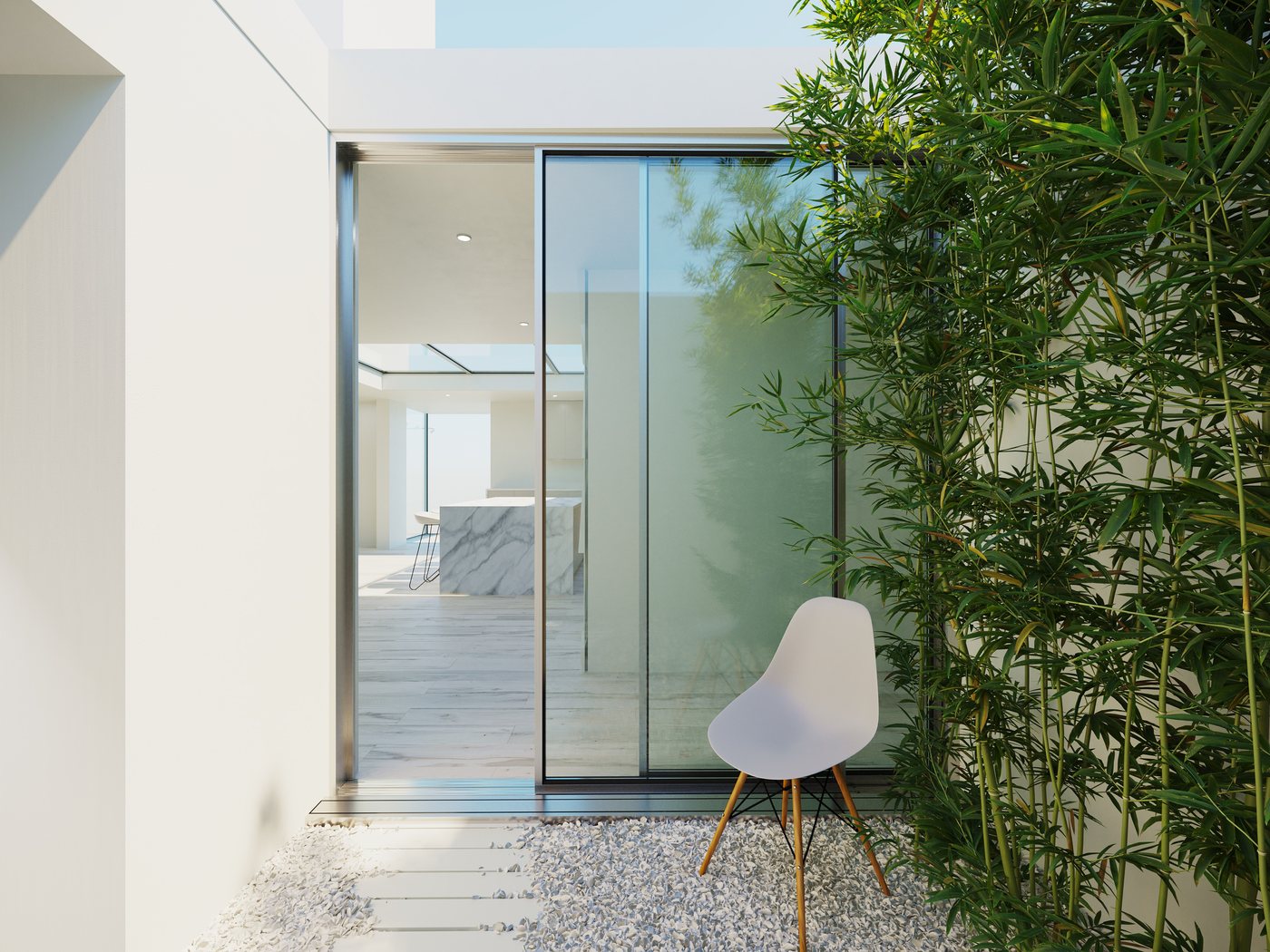 Internal courtyard by day — gravel floor, bamboo planting and sliding glass doors bring sky and greenery deep into the centre of the house