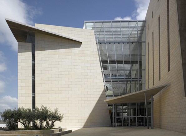 Haifa Supreme Court — entrance forecourt with the glazed bridge canopy and olive tree against the stone mass