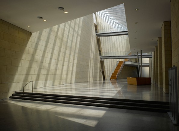 Haifa Supreme Court — top-lit lobby where louvred rooflights cast striped shadows across the angled stone wall