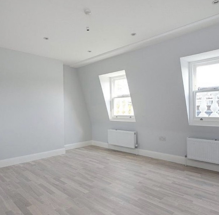 Ifield Road — top-floor bedroom within the reconfigured roof space, lit by paired dormer windows